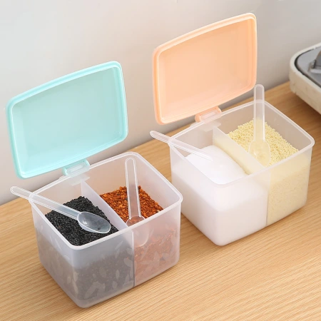 The kitchen seasoning box is an integrated, partitioned, round seasoning box with two compartments. It is a seasoning jar with a spoon for storage The kitchen seasoning box is an integrated, partitioned, round seasoning box with two compartments. It is a seasoning jar with a spoon for storage